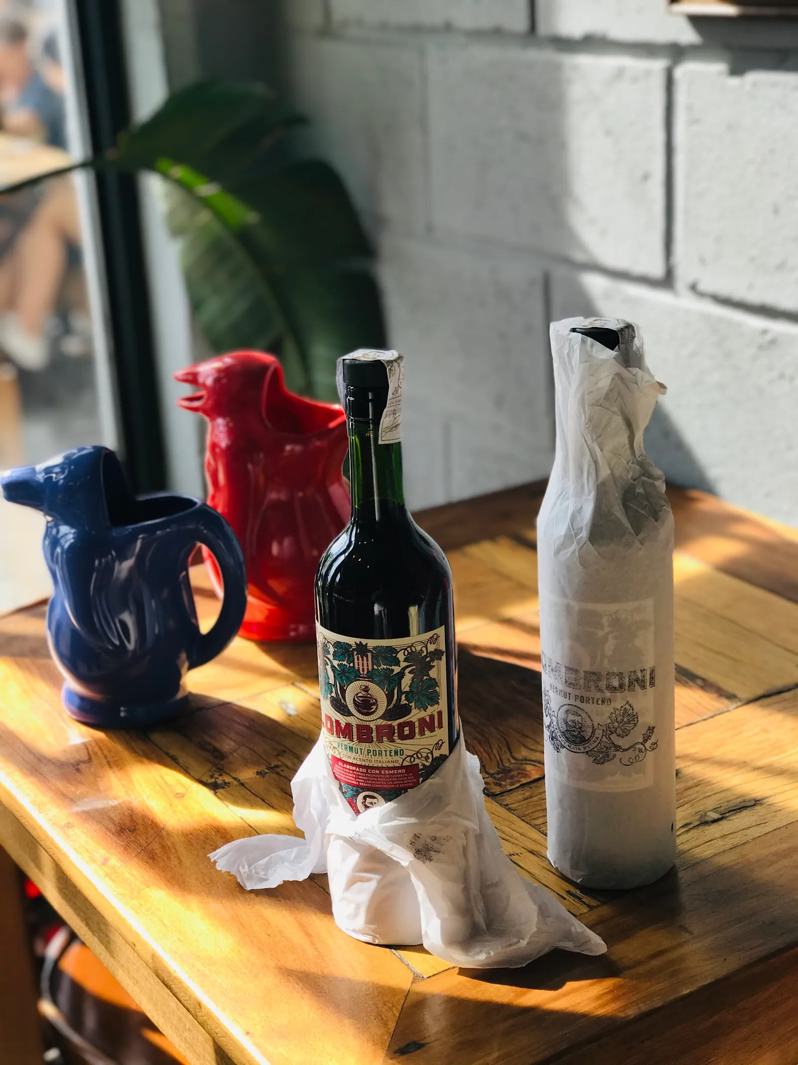 Botellas de vermut y jarras de cerámica sobre una mesa de madera